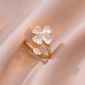 Vista macro de anillo de trébol con circonitas de corazón rosa y acabado dorado en seda - Oro + Anillo Abierto de Trébol Transparente (J0281)
