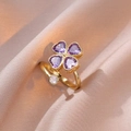 Detalle de anillo de trébol con circonitas moradas de corazón sobre seda rosa suave - Oro + Anillo Abierto de Trébol Púrpura (J0280)