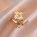 Dettaglio anello a quadrifoglio con zirconi su elegante tessuto di raso champagne - Anello Aperto Quadrifoglio in Zirconia Bianca (J0325)