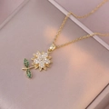 Collana girasole dorata con zirconi bianchi e verdi brillanti su superficie morbida - Collana Rotante a Girasole (X3471)