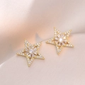 Eleganti orecchini a stella dorati con zirconi su sfondo di seta color champagne - Orecchini a Stella (E0689)