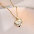 Collier élégant avec pendentif cœur doré serti de zircons sur fond de soie couleur champagne - Or