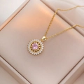 Elegante goldene Halskette mit rosa Zirkonia auf einer hochwertigen beigen Geschenkbox - Halskette mit rosa Zirkonia