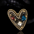Broche cœur asymétrique ornée de pierres colorées et cristaux sur fond noir brillant - Color Block
