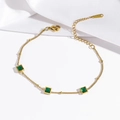Edelstahl-Armband in Gold mit drei quadratischen grünen Zirkonia auf weißer Seide - Armband / Smaragd