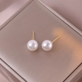 Elegante weiße Perlenohrstecker mit Vergoldung auf seidigem Schmuckkästchen-Hintergrund - Mittel / Weiß