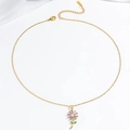 Elegante goldene Halskette mit lila Blumenanhänger und grünen Strassblatt-Akzenten - Sonnenblumen Halskette / Lila Gold