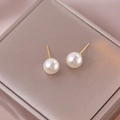 Elegante 8mm Perlenohrringe mit goldenen Steckern auf Champagner-Seidenhintergrund - Mittel / Beige