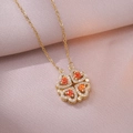 Detailopname van de gouden klaverhanger met oranje zirkoonstenen en witte kleine diamanten - X1205 Stalen Ketting