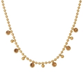 Close-up of gold beaded chain necklace featuring amber crystal and polished metal sphere charms - Champagne