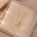 Elegante collana dorata con lettera iniziale H e cristalli di zircone su portagioie - Lettera H (X4203)