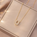 Elegante collana con ciondolo lettera U dorata e pavé di zirconi su raso champagne - Letter U (X4216)