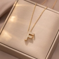 Makroaufnahme der goldenen Buchstabe F Kette mit Zirkonia-Besatz auf feiner Gliederkette - Buchstabe F
