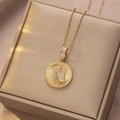 Makroaufnahme einer goldenen Edelstahlkette mit rundem N-Anhänger und Zirkonia-Besatz - Gold - Buchstabe N
