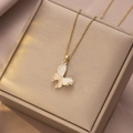 Detailed close-up of a golden butterfly pendant with white shell wings and zircon accents - Gold White Shell-look Butterfly Rhinestone (X4313)