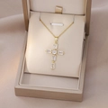 Detail shot of golden cross necklace with emerald cut zircons in a jewelry box - Gold Rectangular Zircon Cross (X2557)
