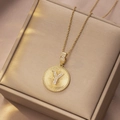Goldene Halskette mit runder Sonnenstrahl-Anhänger Buchstabe Y auf Schmuckschatulle - Gold - Buchstabe Y