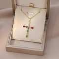 Close-up of gold cross pendant with colorful pear-cut zircon stones in a jewelry box - Gold Multicolor Cross (X2566)