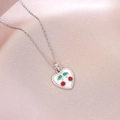Close-up of heart-shaped cherry pendant necklace on soft pink satin fabric background - Heart Enamel Cherry (X4439) / Silver