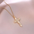 Macro view of golden cross necklace with multi-shaped crystals on pink silk fabric - Geometric Pavé Style (X4412)