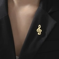 Détail d'une broche clé de sol dorée épinglée sur le revers d'un costume noir chic - Style Symbole Musical (Couleur Or)