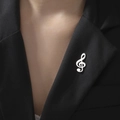Vue détaillée de la broche clé de sol argentée sur le revers d'un costume noir chic - Style Symbole Musical (Couleur Acier)