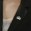 Détail macro d'une broche couronne argentée avec découpe cœur sur un revers de blazer noir - Style Couronne (Couleur Acier)