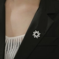 Détail d'une broche rayon de soleil blanche épinglée sur le revers d'un blazer noir - Style Lumière du Soleil (Couleur Acier)