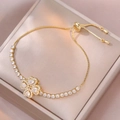 Bracciale a quadrifoglio dorato regolabile con zirconi bianchi in una scatola per gioielli - Bracciale Cuore Rotante
