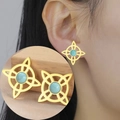 Detailed macro view of Celtic knot stud earrings with turquoise stones in gold finish - Gold Color Witch Knot With Blue Stone