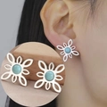 Detail of Celtic knot stud earring with blue gemstone inlay worn on female model ear - Steel Chinese Knot