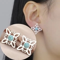 Detail of Celtic witch knot earrings with turquoise stone on soft pink silk - Steel Four S Witch Knot