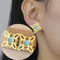 Detail of vintage gold Celtic knot earrings with turquoise gemstone inlay on model - Gold Four S Witch Knot