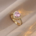 Macro view of golden heart ring with pink gemstone and halo diamonds on satin background - Pink Heart Main Stone / Pink/Gold (J0599)