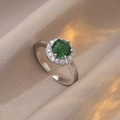 Macro view of adjustable silver ring with green zircon and halo diamond setting - Green Round Main Stone / Green/Silver (J0602)