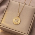 Goldene Edelstahlkette mit Kristallpavé-Buchstabe Z Anhänger auf seidigem Stoffhintergrund - Gold - Buchstabe Z