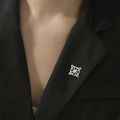 Broche de nudo celtico de acero inoxidable plateado en la solapa de un traje negro - Nudo de Bruja Acero