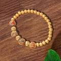 Vintage-Armband aus goldmatten Perlen mit bunten Emaille-Anhängern auf dunklem Holz - Bunter Ethno-Stil (TS0463)