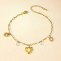 Detailed macro of gold heart and zircon charms on a delicate stainless steel anklet - Hollow Heart Waterdrop Zircon Style (TL0022)