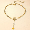 Detailed macro view of a double-layer gold anklet with zircon charms and clover pendant - Hollow Clover Waterdrop Style (TL0014)