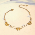 Double-layered gold anklet featuring bow pendants and white beads in soft sunlight - Double Layer Three Bowknots Style (TL0029)