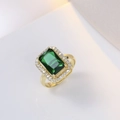 Dettaglio macro di un anello d'oro con pietra verde rettangolare e contorno di zirconi - Stile Halo Verde Scuro Taglio Smeraldo (J0015 Verde)