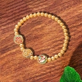 Mattes Goldperlenarmband mit Vintage-Blumen-Emaille-Anhängern auf dunklem Holzhintergrund - Gold Emaille Pfingstrose (TS0455)