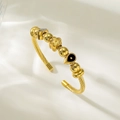 Vue détaillée du bracelet câble en acier doré avec breloques fleurs et perles - Style Trèfle à Quatre Feuilles et Géométrique Noir (TT0848)