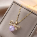 Elegante collana di perle viola con pendente a fiocco in zirconi e acciaio dorato - Stile Fiocco con Perla Viola (X0391)