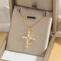 Golden cross necklace with white pearls and sparkling zircon stones in a jewelry box - Gold