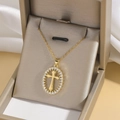 Gold oval pendant necklace featuring a cubic zirconia cross in a luxury jewelry box - Gold