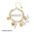 Bohemian gold stainless steel bracelet with evil eye and heart charms in white background - Evil Eye Hamsa Hand Gold Style