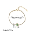 Detail of gold chain bracelet featuring green gemstone pendant with zircon halo and lobster clasp - Round Emerald Style (SL110047)
