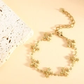 Detailed shot of golden stainless steel bracelet with seven cross-shaped charms and clasp - Cross (SL-010) / Gold